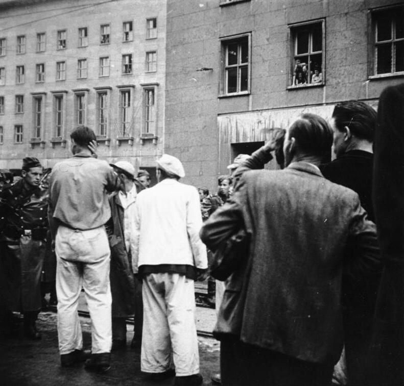 Svart-hvitt dokumentarfoto av arbeidere og folk samlet i gata under oppstanden 17. juni 1953