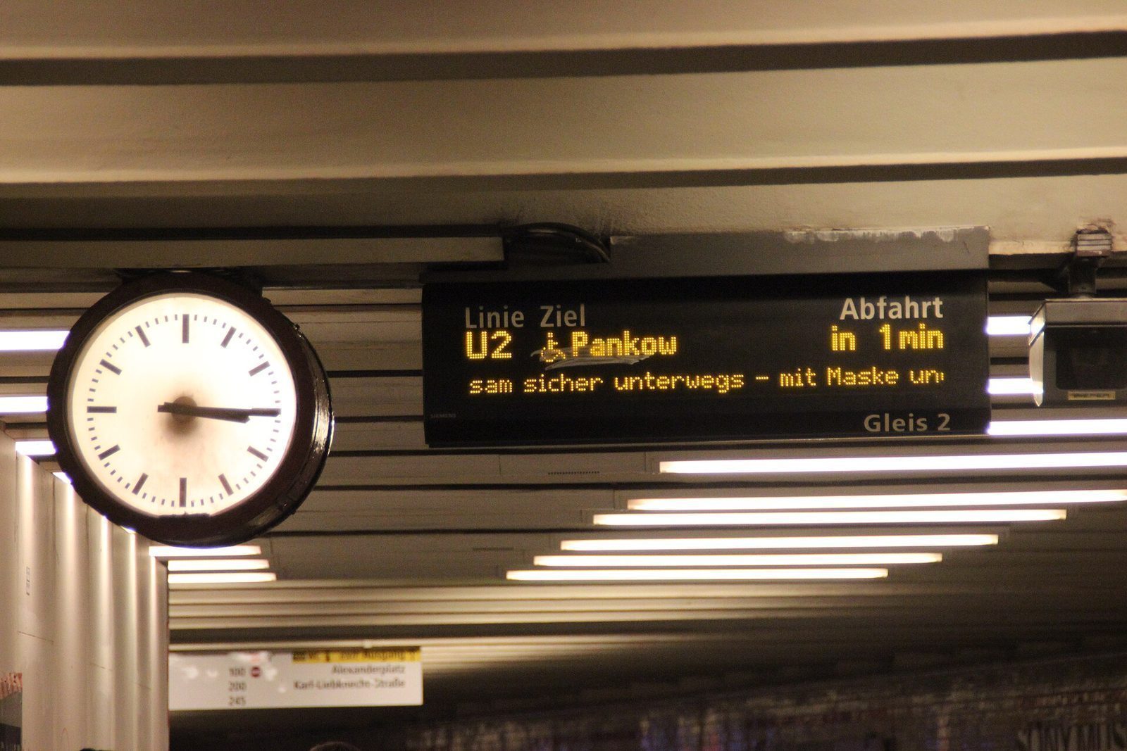 Stasjonsur og avgangstavle under taket på U-Bahnhof Alexanderplatz, med U2 mot Pankow om ett minutt