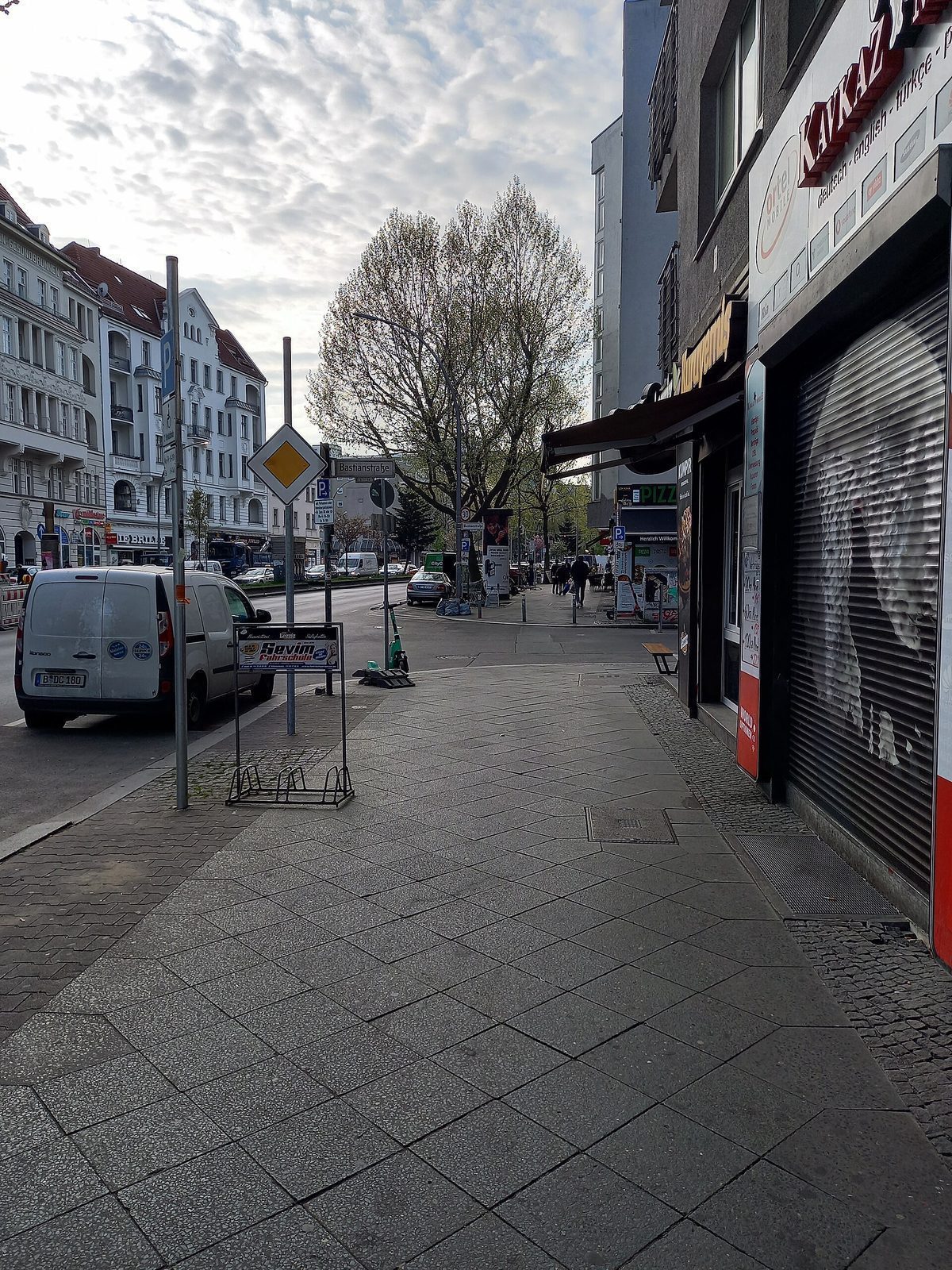 Butikk med nedrullede stålgardiner og tomt fortau i Badstraße