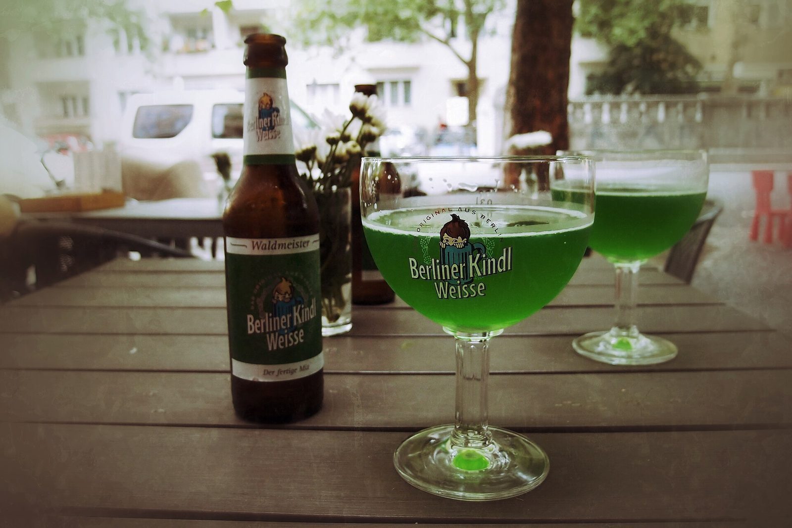 Berliner Weisse med grønn skogsmerkesirup i vidt glass med sugerør
