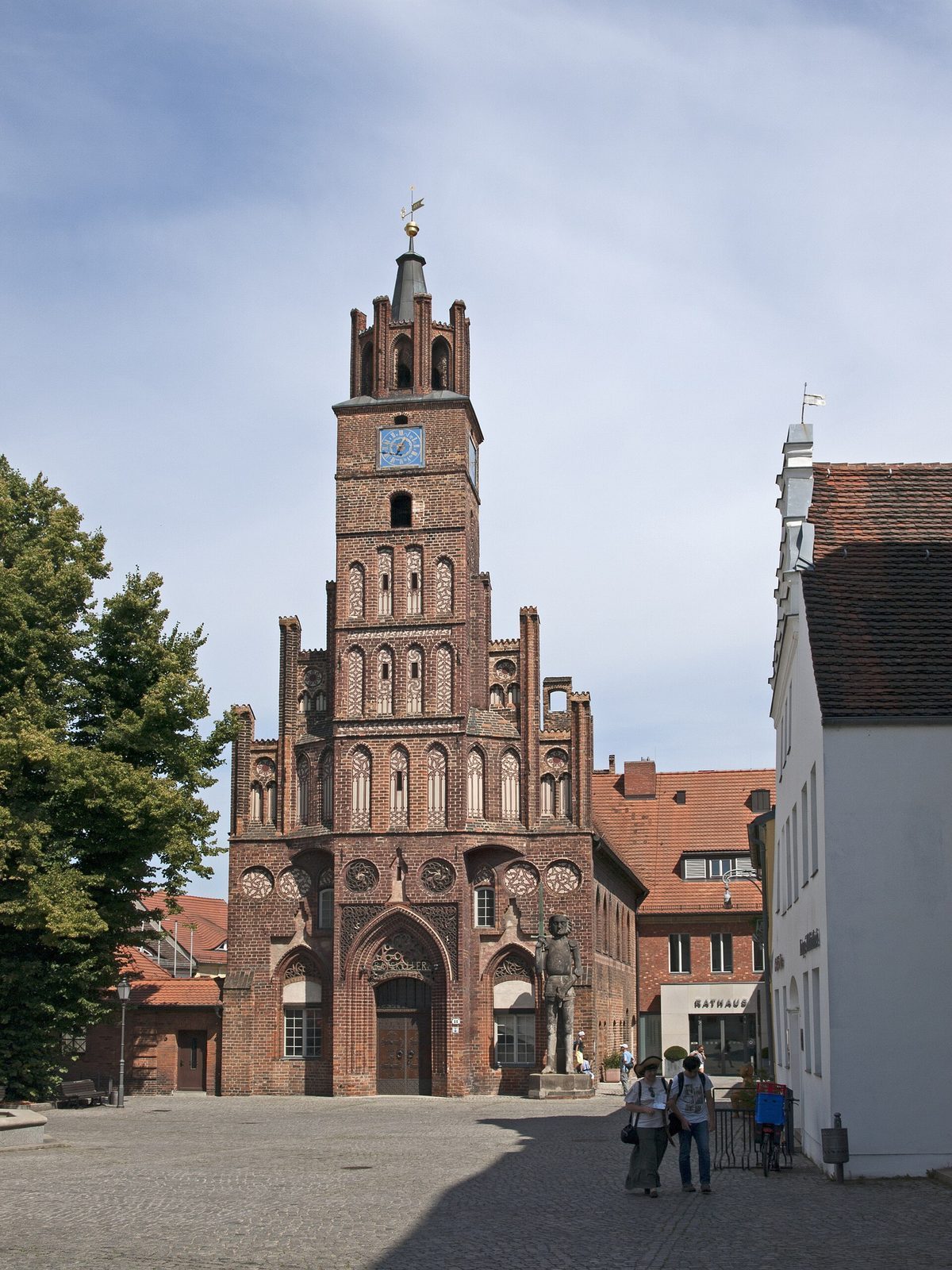 Det gotiske Altstädtisches Rathaus i Brandenburg an der Havel, med det høye teglklokketårnet og Roland-statuen foran på brosteinstorget