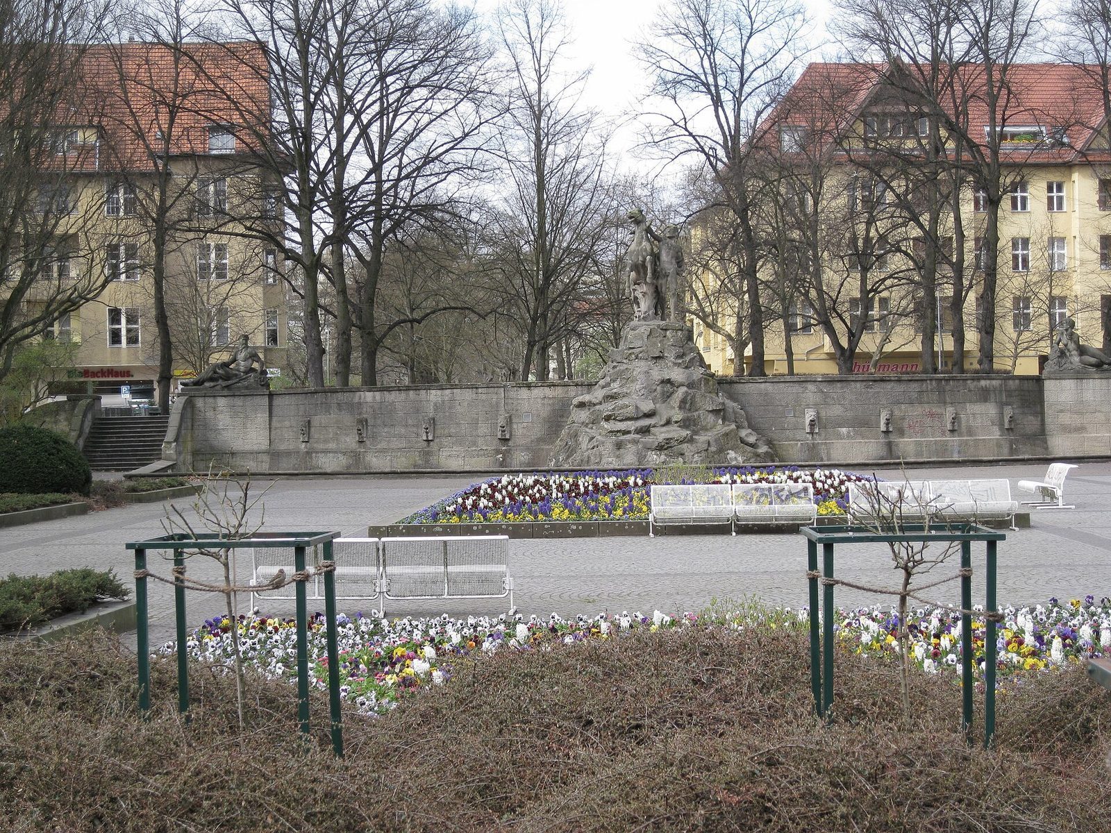 Fontenen med Siegfried-gruppen pa Ruedesheimer Platz, med blomsterbed og benker foran