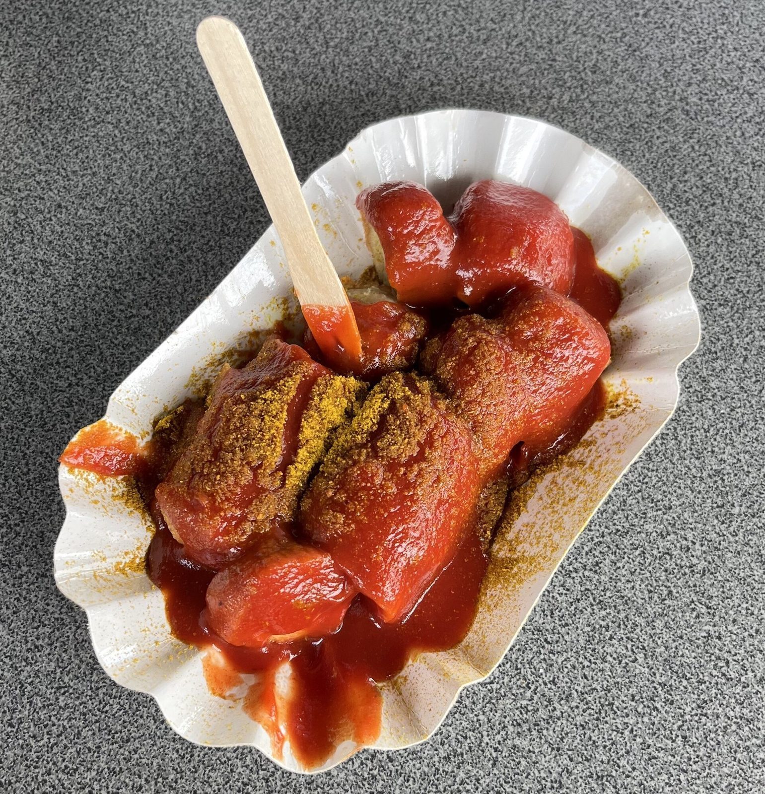 Currywurst i skiver med karrikrydret ketsjup og et lite trespyd