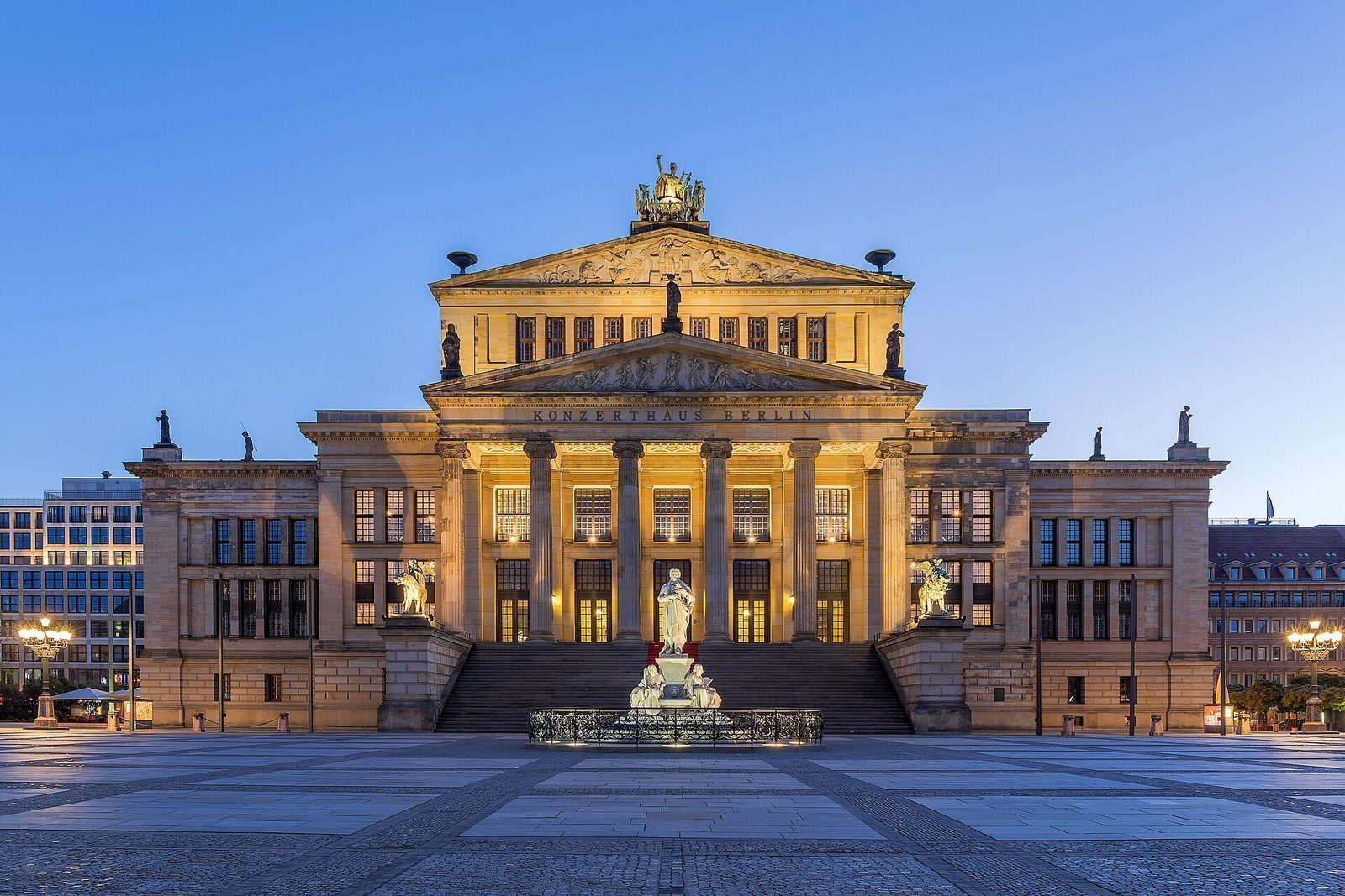 Konzerthaus på Gendarmenmarkt opplyst i blåtimen, med fritrappa og søylefasaden