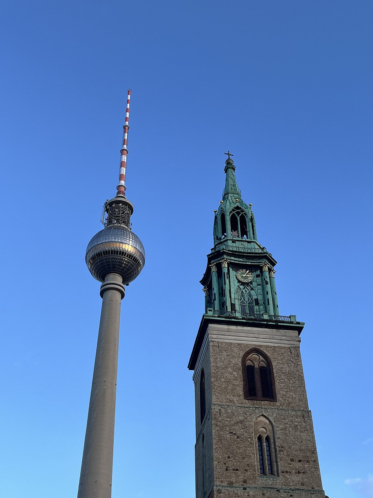 Marienkirche med sitt grønne kobberspir foran den skinnende kula på Fernsehturm