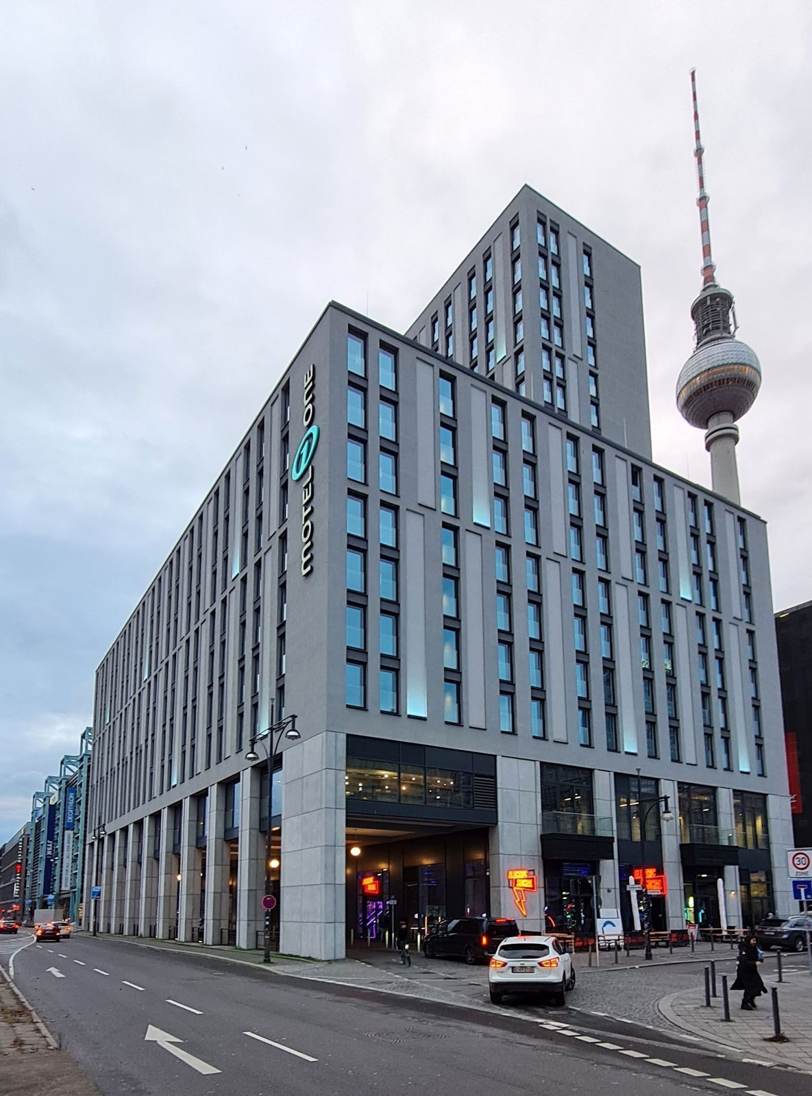 Hotellbygning nær Alexanderplatz med Fernsehturm som stikker opp bak taket