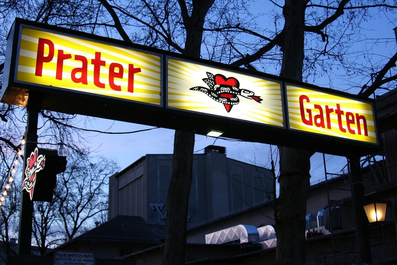 Neonskiltet «Prater Garten» over inngangen i Kastanienallee i skumringen