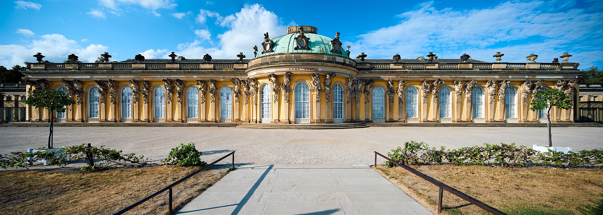 Fasaden på Schloss Sanssouci med gul puss og kuppelen midt i bygningen