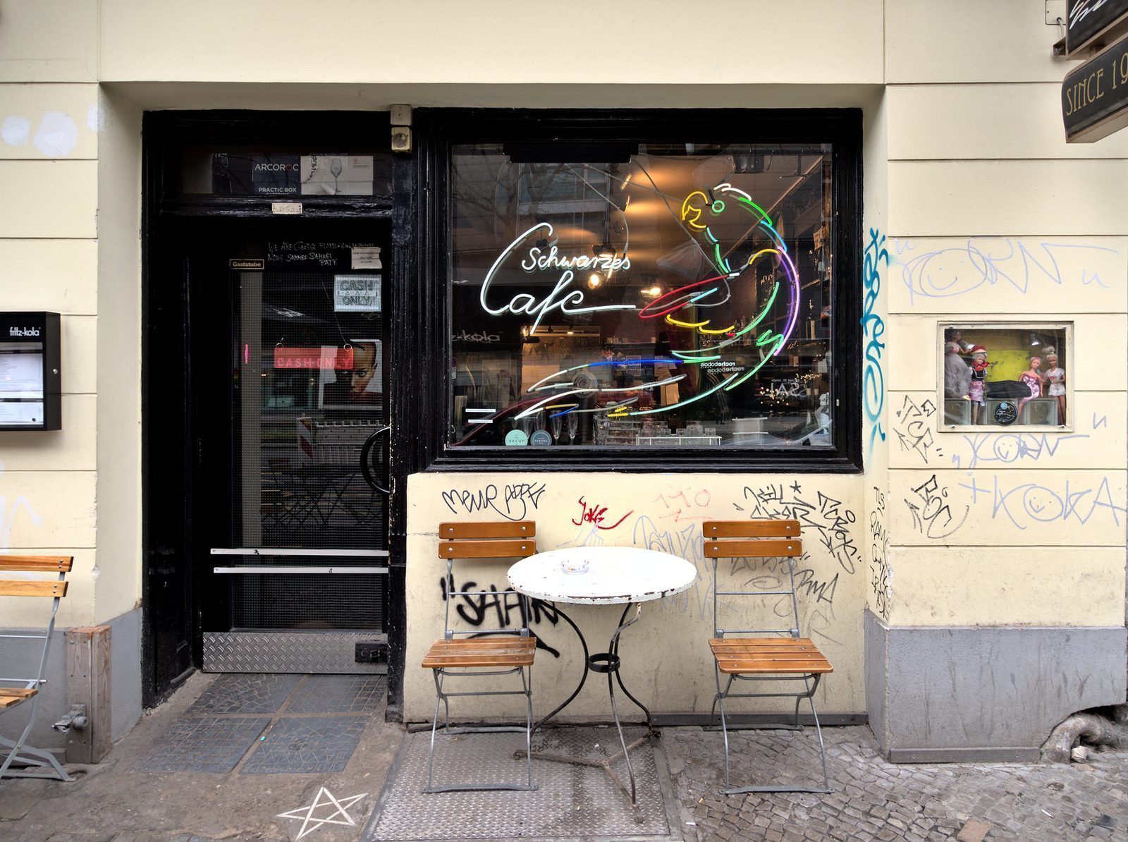 Kafébord og to stoler på fortauet utenfor Schwarzes Café i Kantstraße