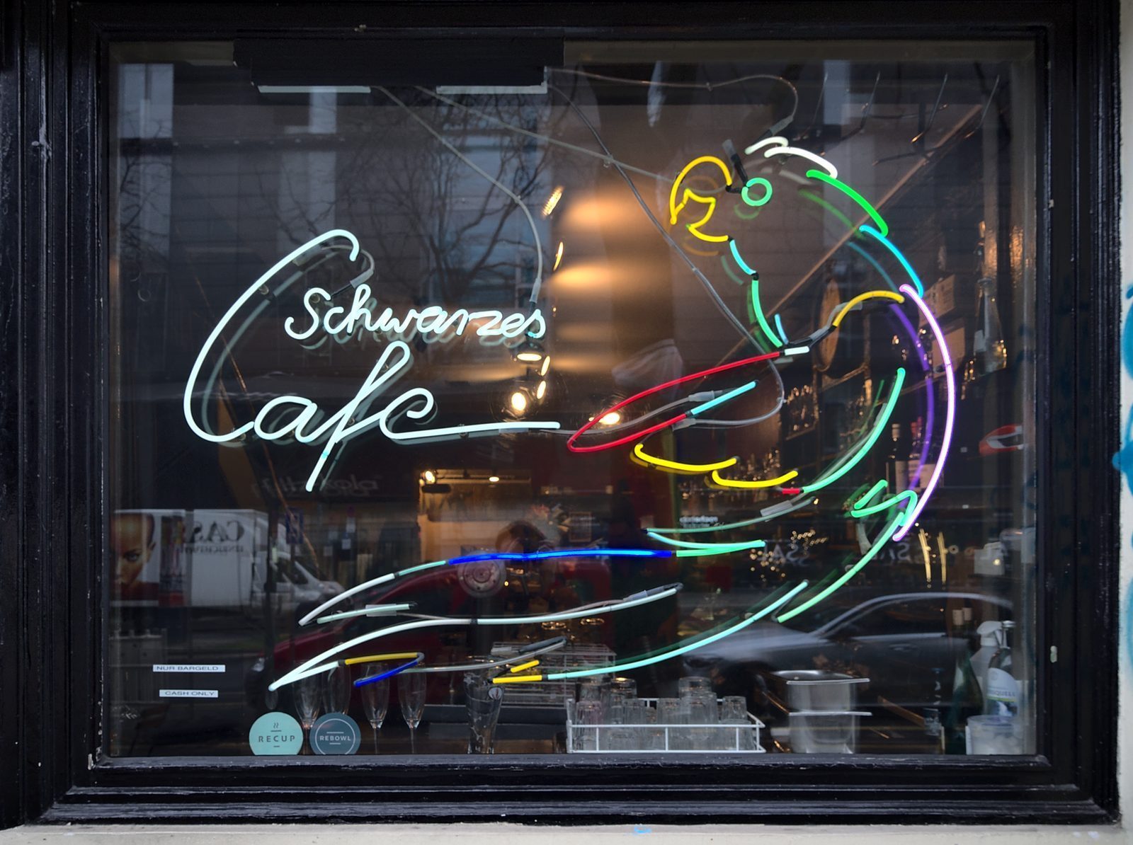 Neonskiltet til Schwarzes Café i vinduet, med «Cash only»-lapp nederst