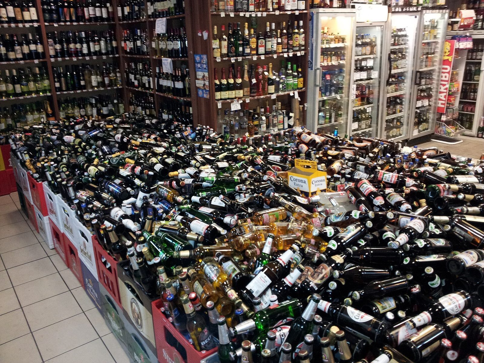 Innsiden av en Späti med hyller av vin og sprit og haugevis av pantflasker i kasser