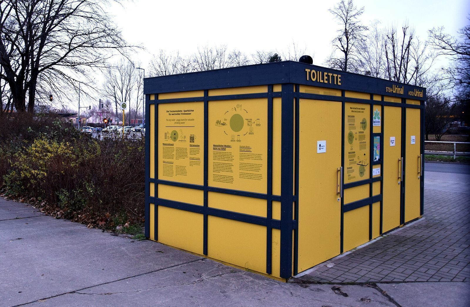 Gul toalettpaviljong i Marzahn med informasjonstavler om tørrtoalettet