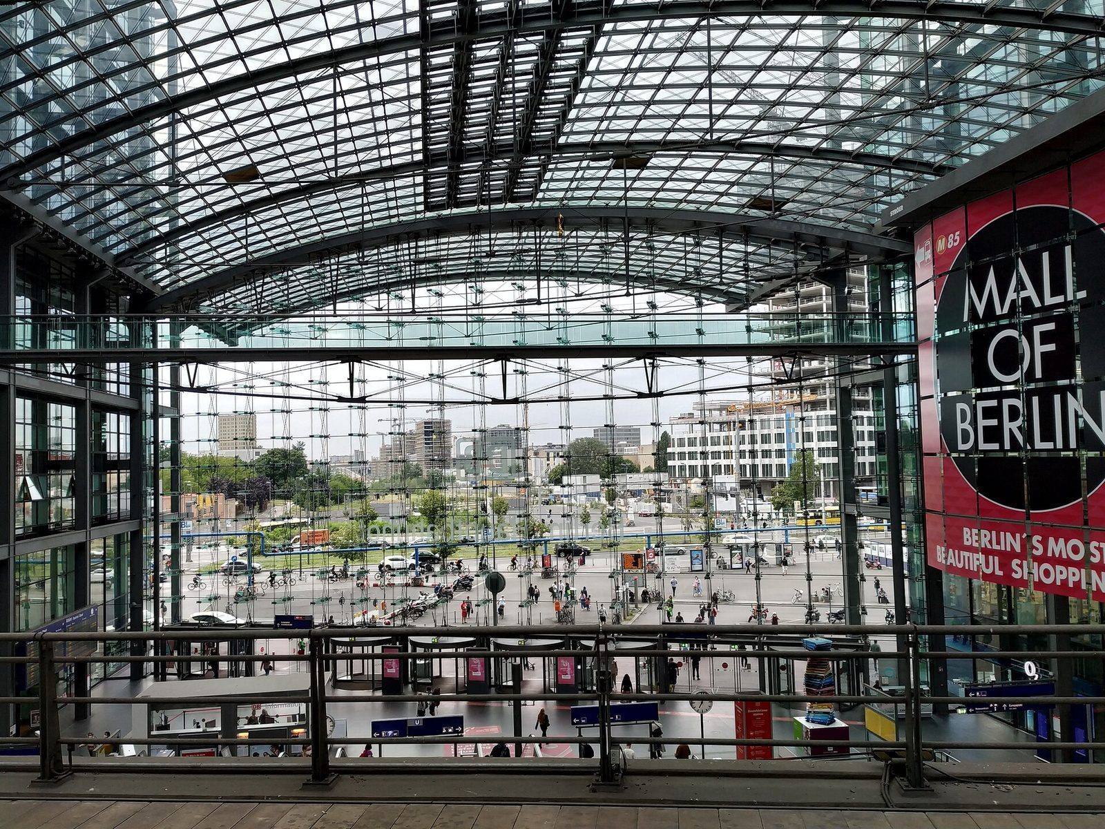 Innsiden av Berlin Hauptbahnhof med den buede glasshvelvingen og utsyn mot forplassen