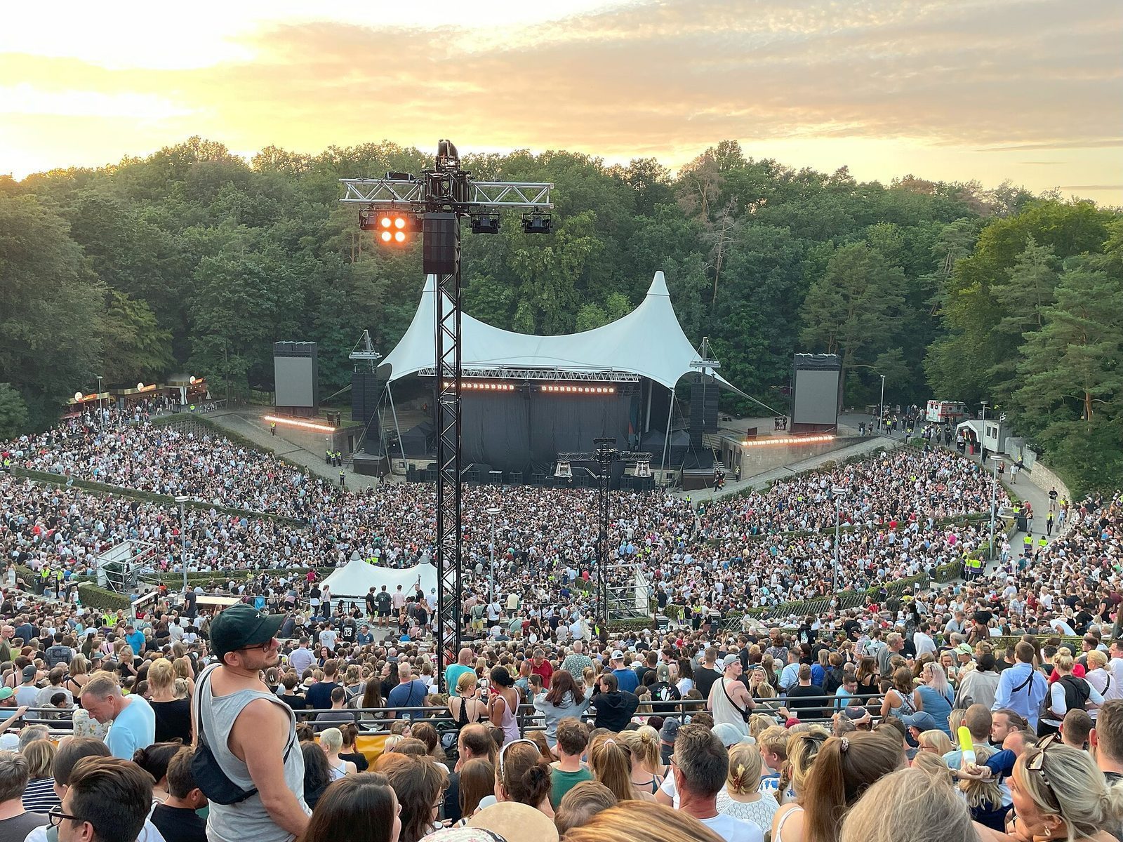 Fullsatt Waldbühne i solnedgang, med scenen og skogen bak amfiet