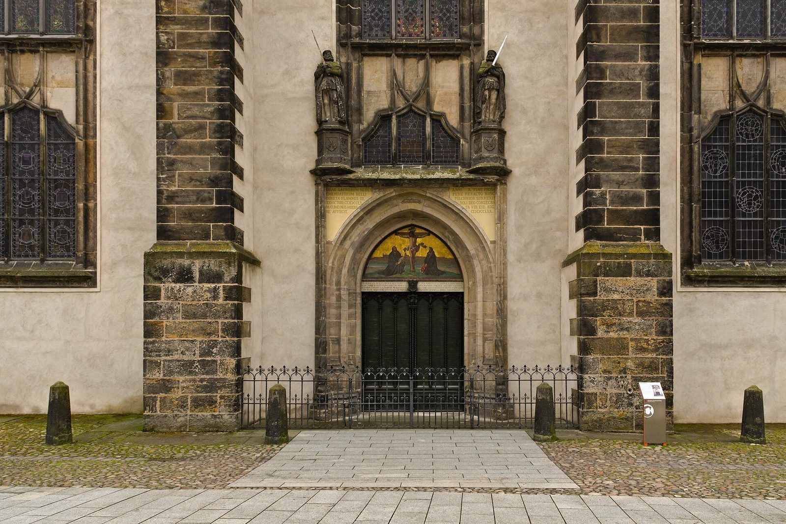 Bronseporten på slottskirken i Wittenberg der Luther etter tradisjonen slo opp de 95 tesene, flankert av to statuer