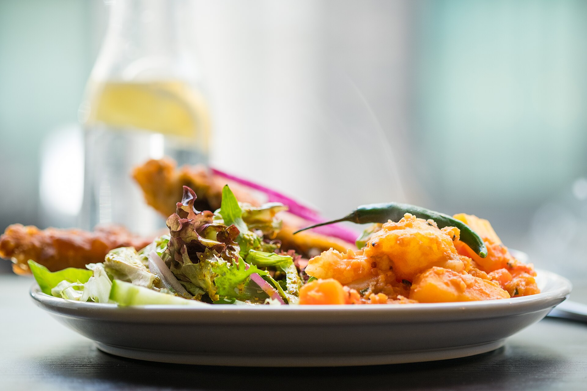 Indisk måltid med curry, ris og nystekt naanbrød på en tallerken