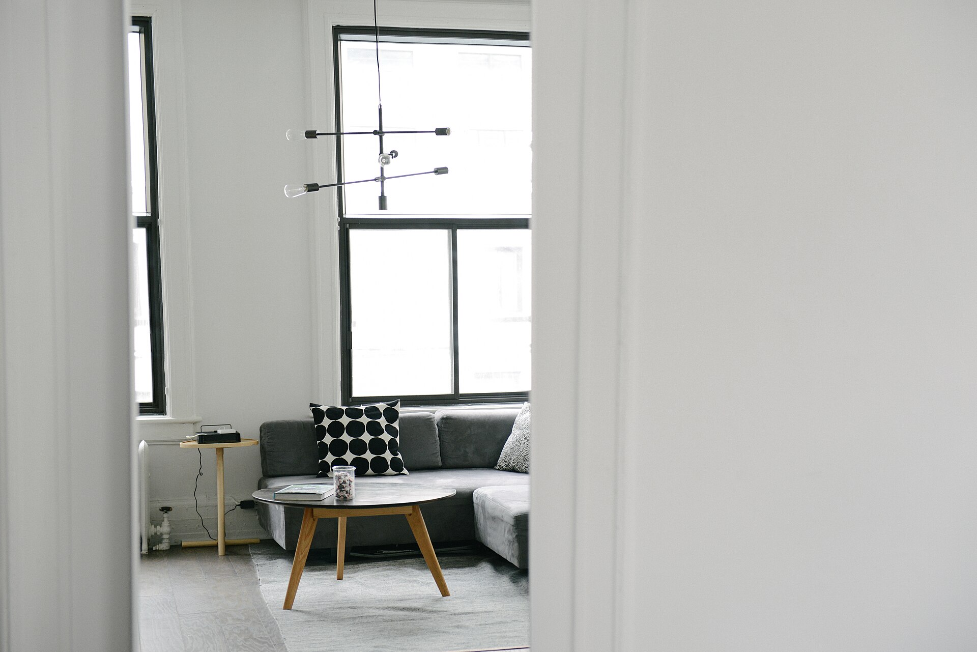 Lys stue med sofa og lavt bord ved et stort vindu